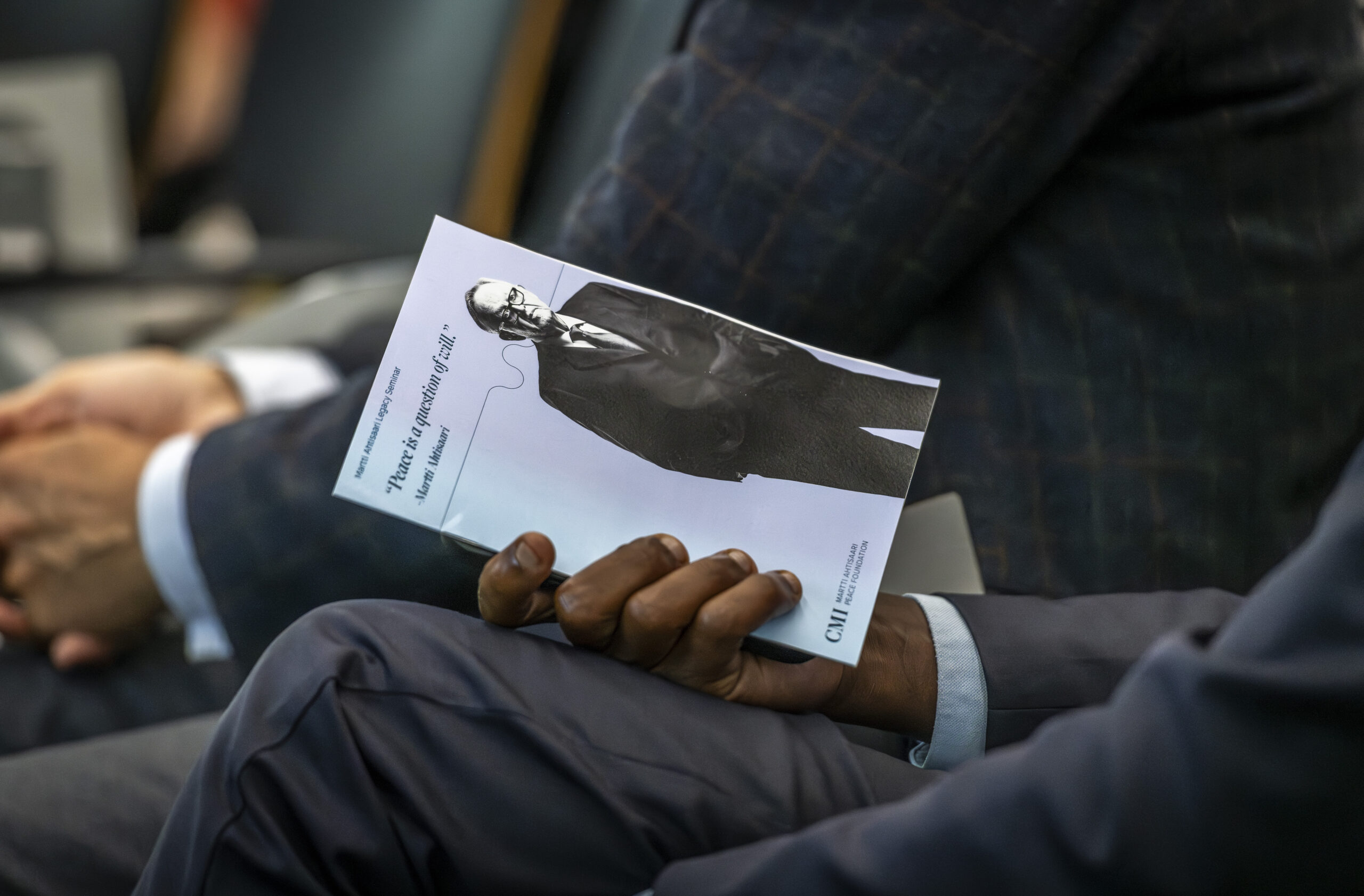 A hand holding Legacy Seminar flyer.