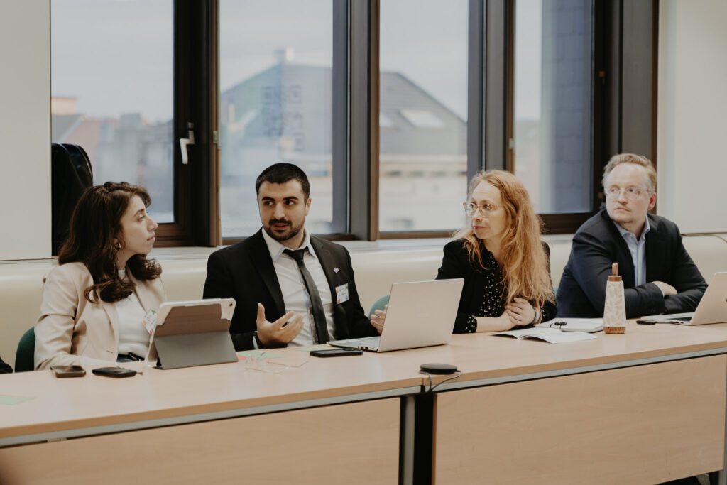Participants seated at a table during the YPS Conference and week in Brussels.