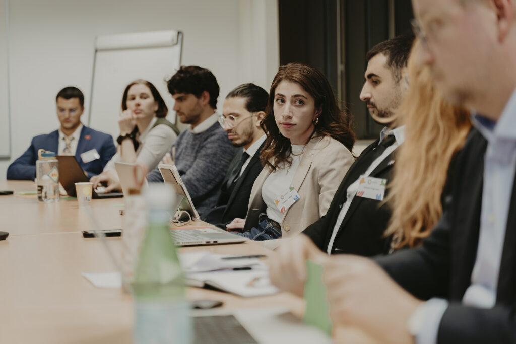 Participants seated at a table during the YPS Conference and week in Brussels.