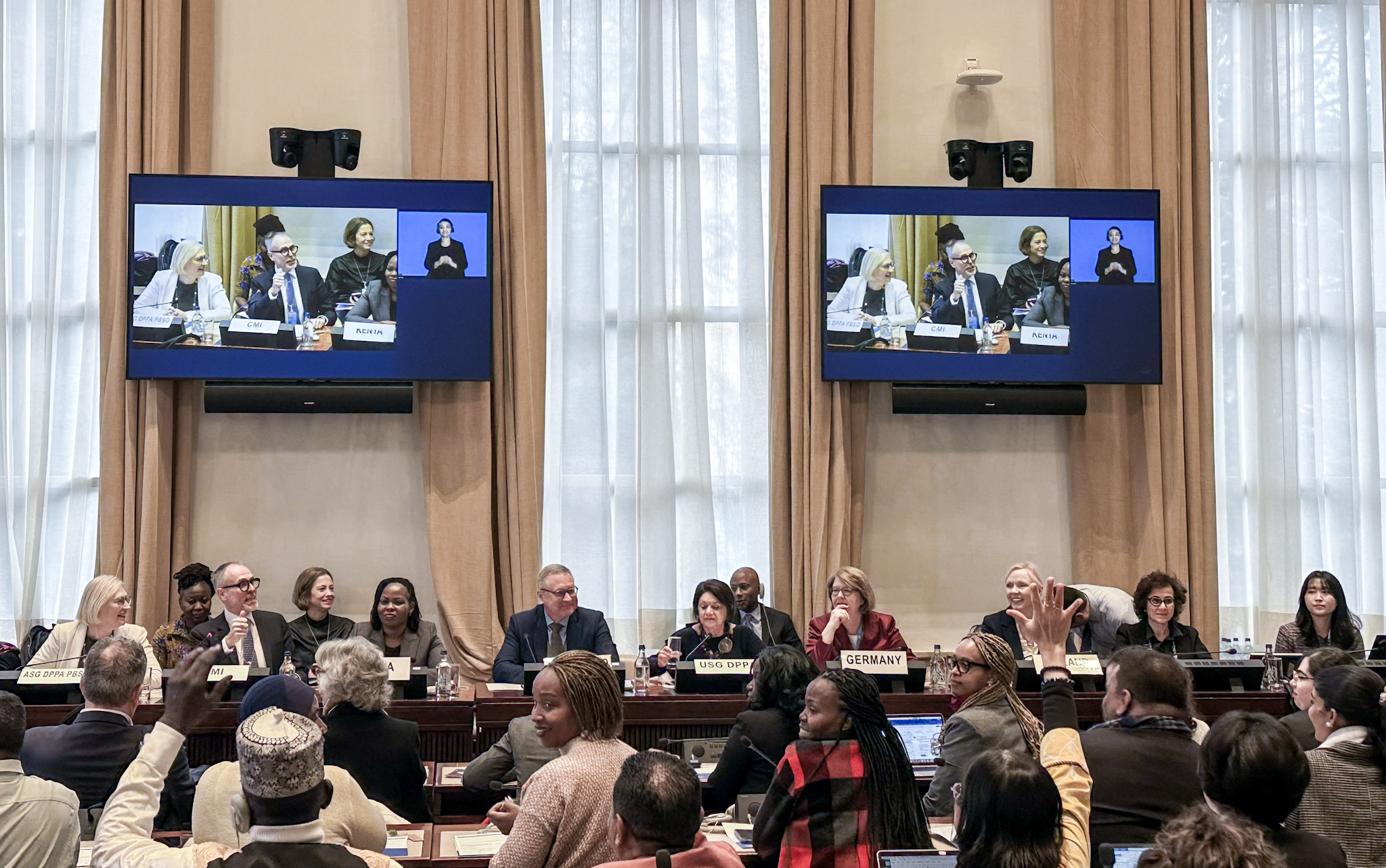 Participants in the foreground and panellists in the background