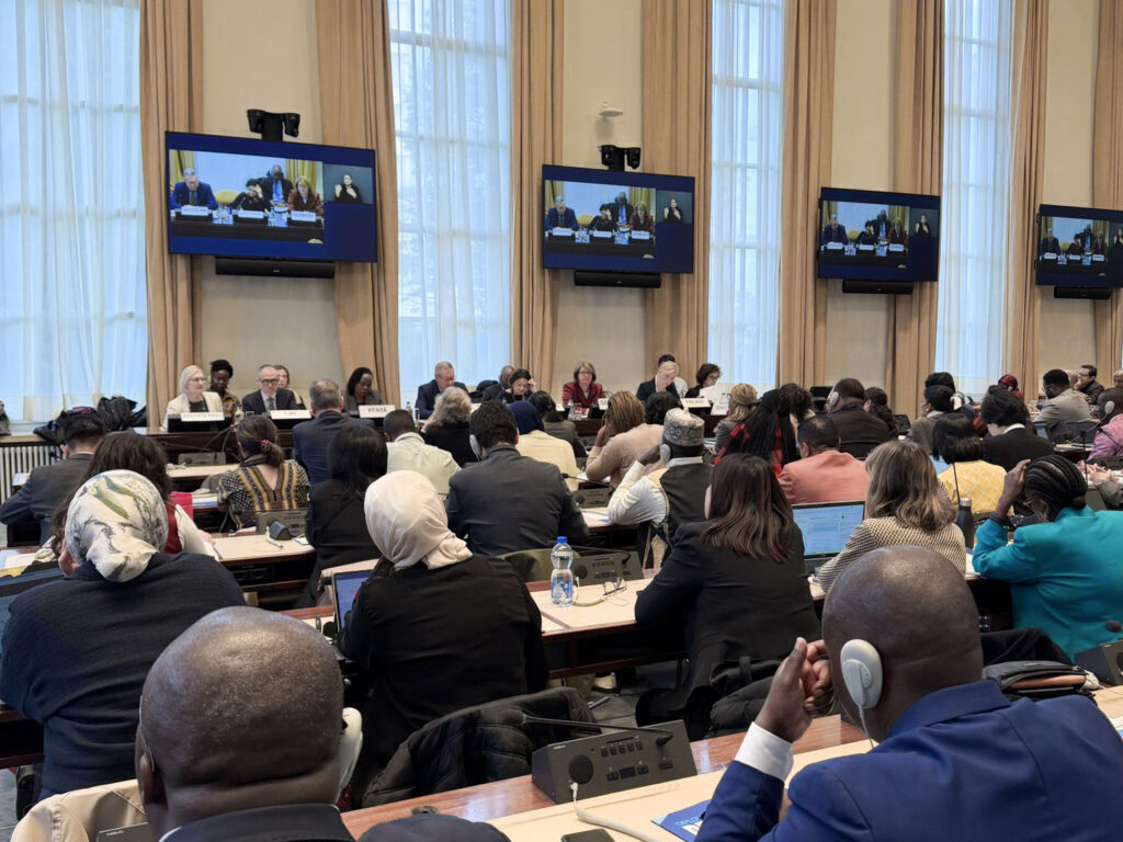 Participants in the room with panellists in the background.