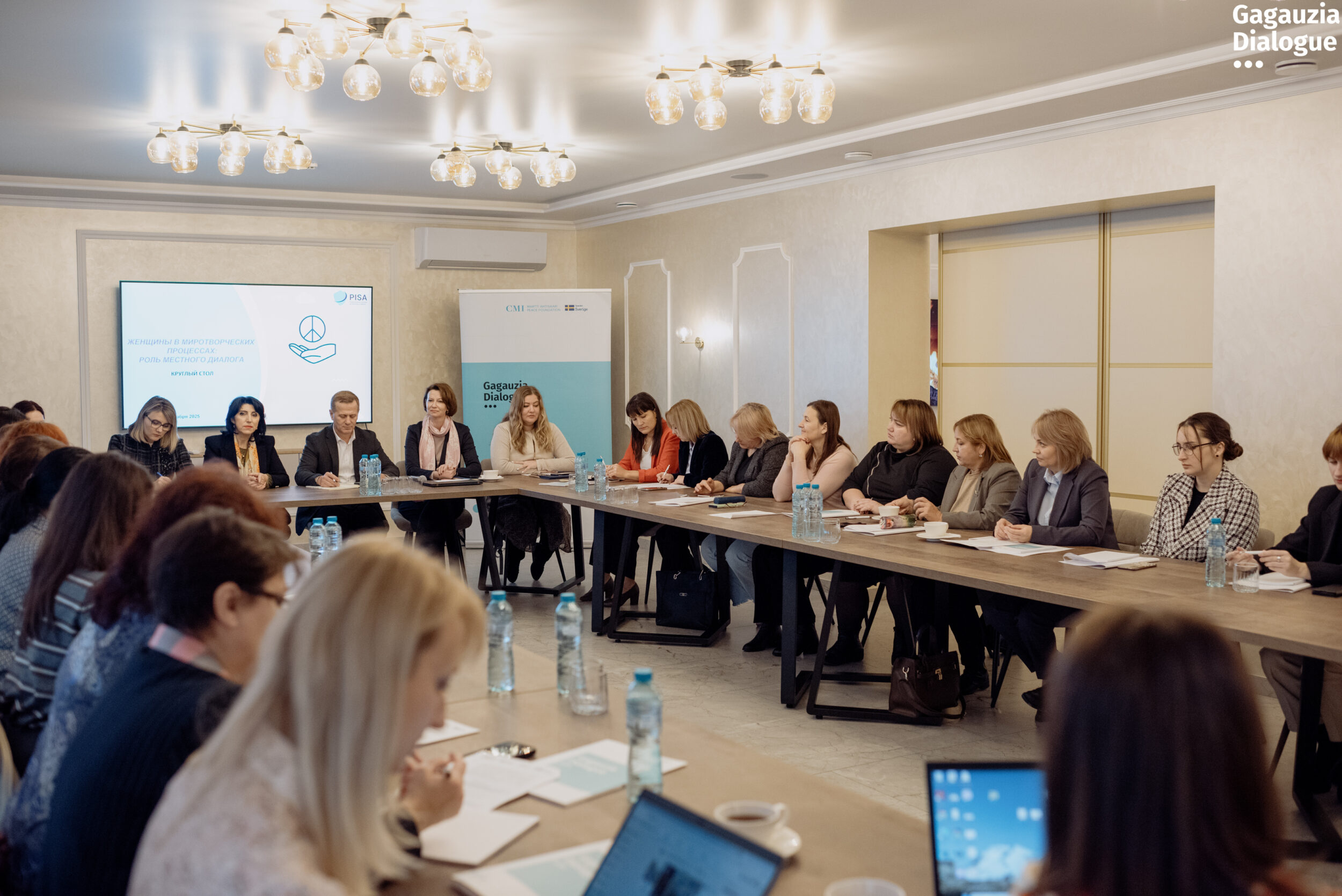 Participants in room at tables.