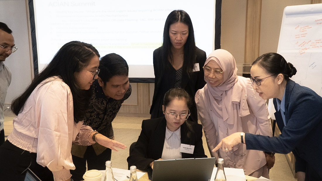 Participants gathered at a computer