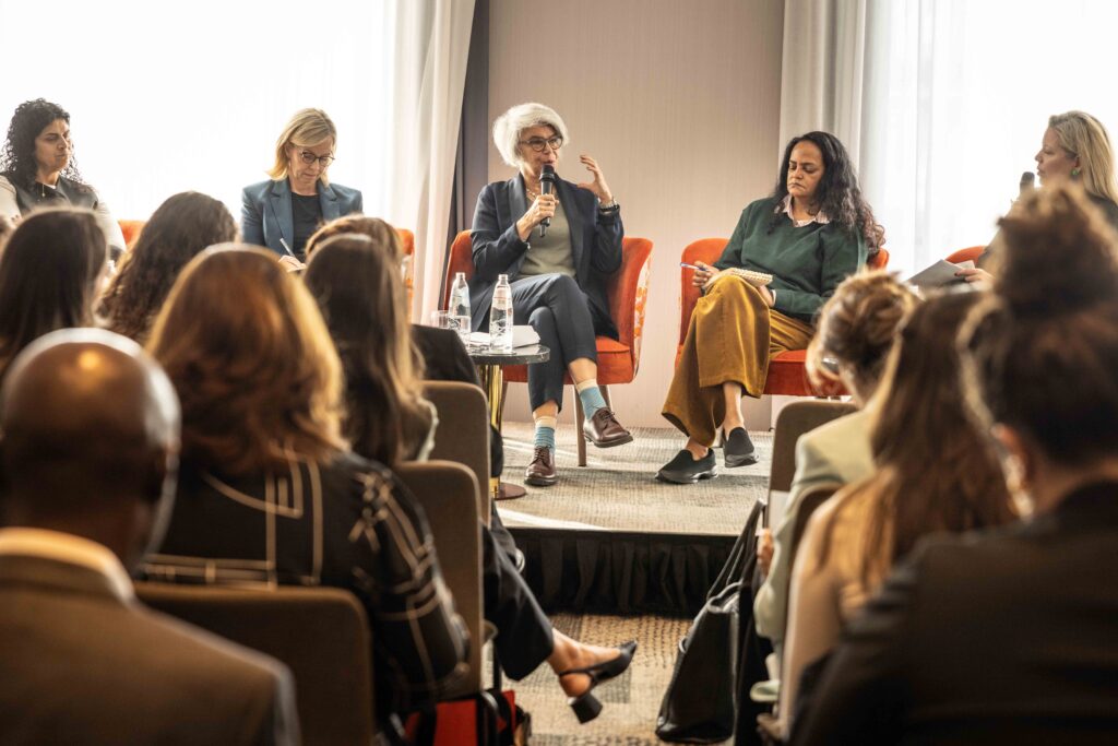 Panel of people sitting and talking in front of a crowd